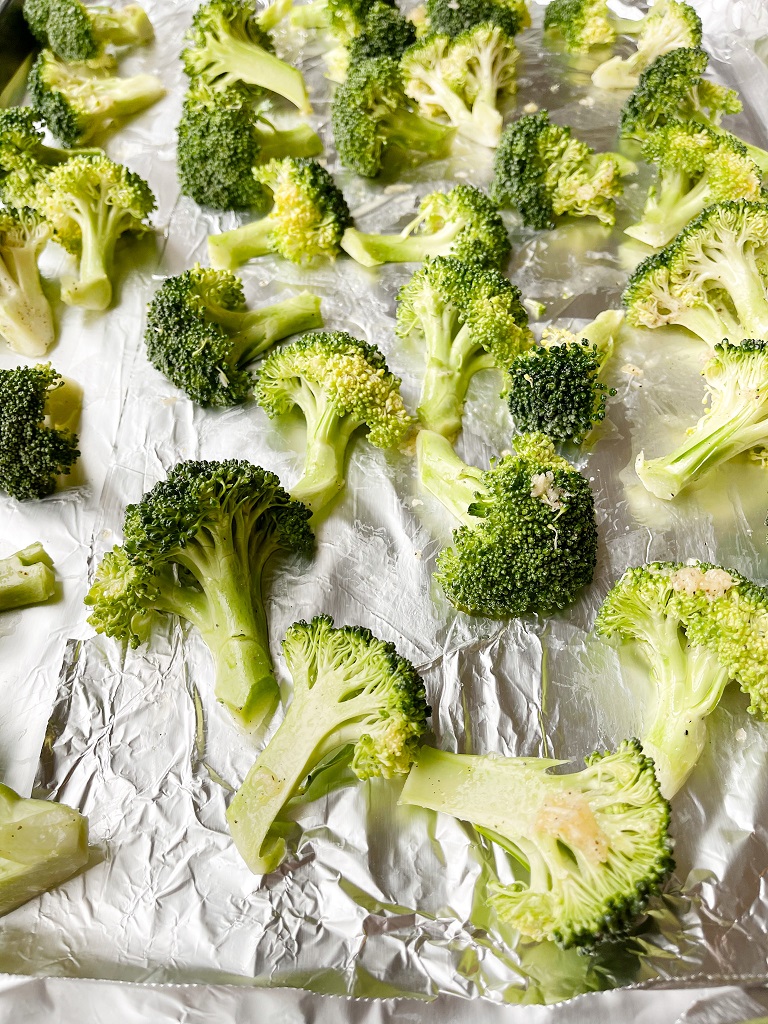 olive oil, salt, black pepper and garlic on broccoli for easy oven-baked broccoli
